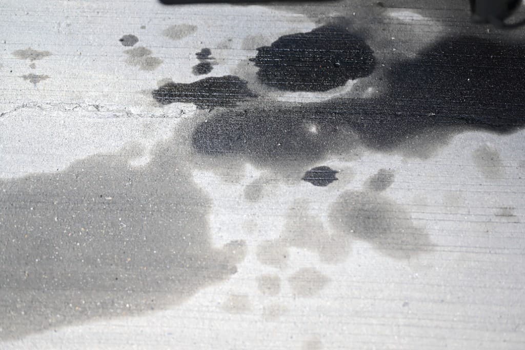Workshop floor with heavy oil and grease stains before treatment